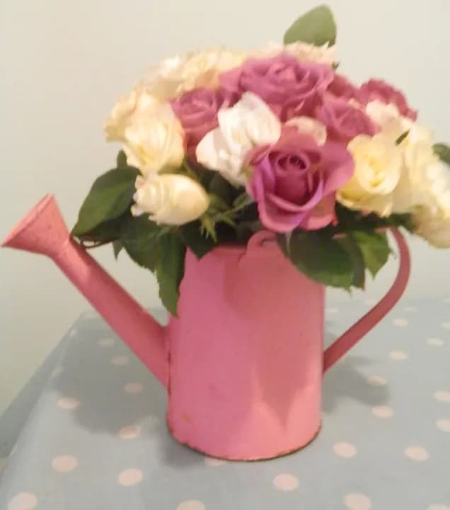 Pink and white roses in a watering can